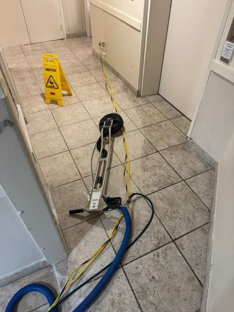 Tile and grout cleaning in progress with a hard-surface cleaning tool in a Miami home
